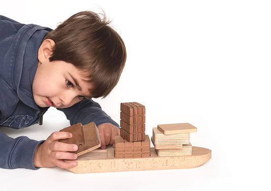 Niño jugando con un juego de bloques de madera de construcción